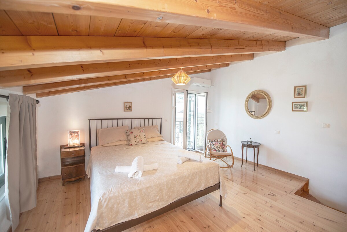 Encantadora habitación estilo loft con un cálido techo de madera, una cómoda cama doble y una suave iluminación natural. Amueblado con buen gusto con detalles vintage y acceso a un balcón privado, perfecto para un retiro tranquilo.