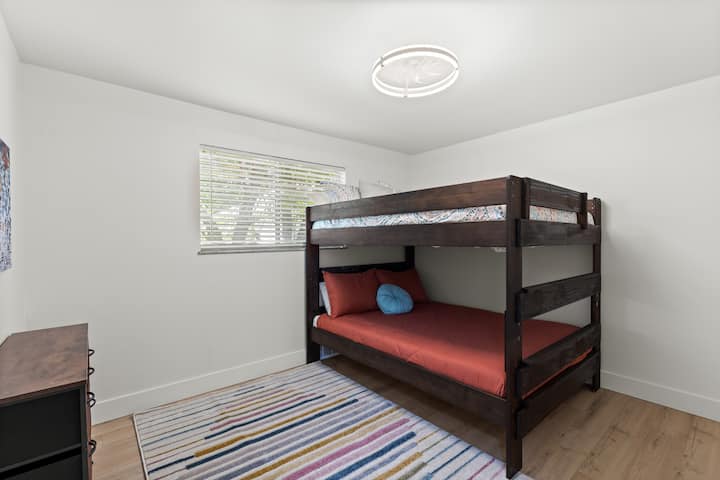 Questi 2 letti queen size sono disposti a castello per consentire letti più grandi e fornire spazio extra sul pavimento.  