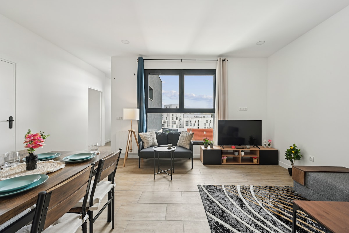 Sebule yenye nafasi kubwa na angavu, yenye sofa kubwa yenye starehe na mapambo ya kisasa. Inafaa kwa ajili ya kupumzika au kufurahia wakati wa utulivu.