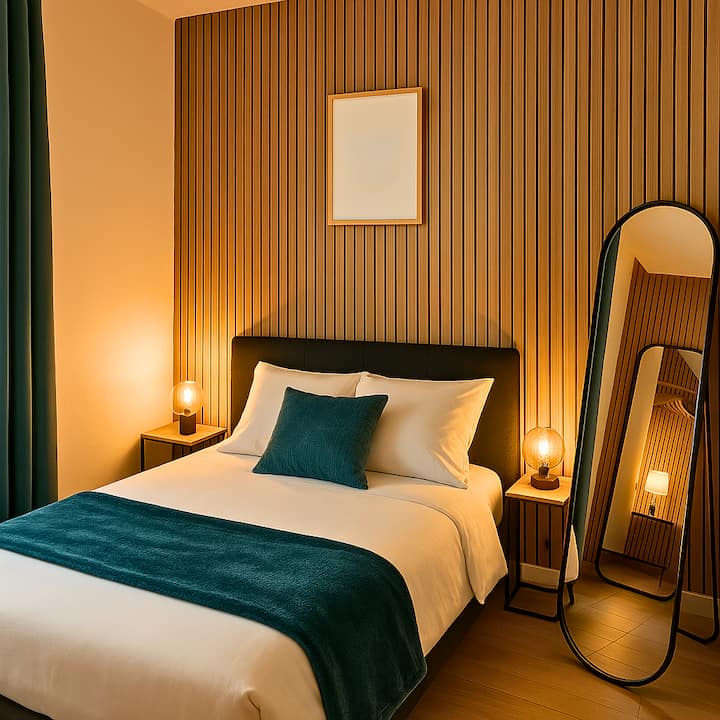 Cette chambre moderne et accueillante offre un lit confortable avec une literie blanche et des touches de vert. Le mur apporte une touche chaleureuse, tandis que le miroir et la lampe de chevet ajoutent une élégance fonctionnelle à l'espace