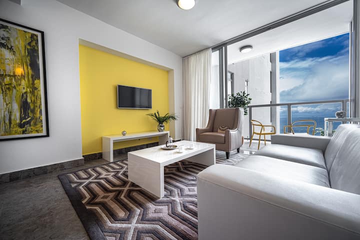 Მისაღები ოთახი ოკეანის ხედით და აივანზე გასასვლელი დასაჯდომი ადგილით.