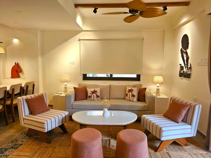 Bright pastel lounge with luxe decor, cozy chairs, and stylish lighting. Step outside through sliding doors for a dip in your private pool-relaxation has never looked so good!