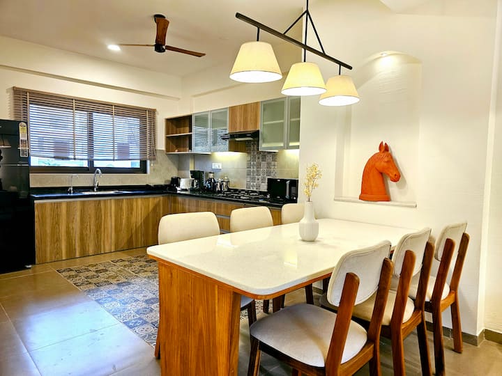 Step into this inviting living space with a fully equipped kitchen, stylish wooden dining table, and modern amenities-your cozy retreat for delicious meals and hearty conversations.