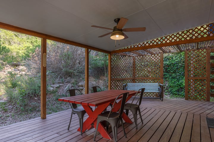 The side patio has a picnic table that can seat 6 (we have extra chairs) and a vintage glider. There's an outdoor ceiling fan to keep you cool and bug-free. Behind the patio and cabin is a scenic cliff that surrounds you with nature.
