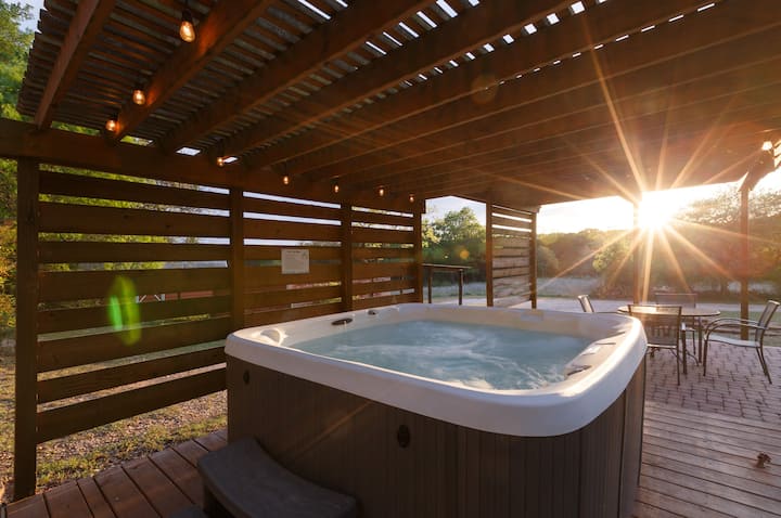 Our hot tub seats 6 and sits under a shade screen that filters sunlight during the day and is lit up by our romantic string lights at night. Next to the hot tub is a table and chair set and the fire ring is just beside them. It's lovely!