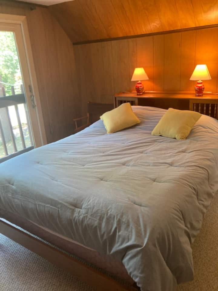 Chumba cha kulala cha ghorofani kilicho na mwonekano wa sehemu ya ziwa ni kitanda cha ukubwa wa malkia.  Kuna kabati na friji ya droo. 