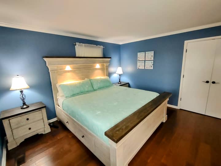 Cama posturpedic tamaño king con dos almohadas posturpedic densas y dos almohadas ligeras y esponjosas. El marco de la cama incluye dos luces táctiles para leer. Las mesitas de noche incluyen un puerto USB para cargar. Se coloca un protector contra sobretensiones a cada lado de la cama para que lo uses.