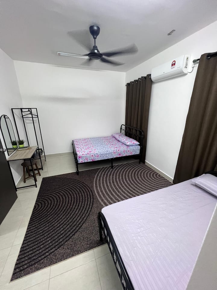 La chambre comprend 1 lit queen size, 1 lit simple, une coiffeuse avec un miroir et une armoire ouverte avec une tringle et un porte-vêtements