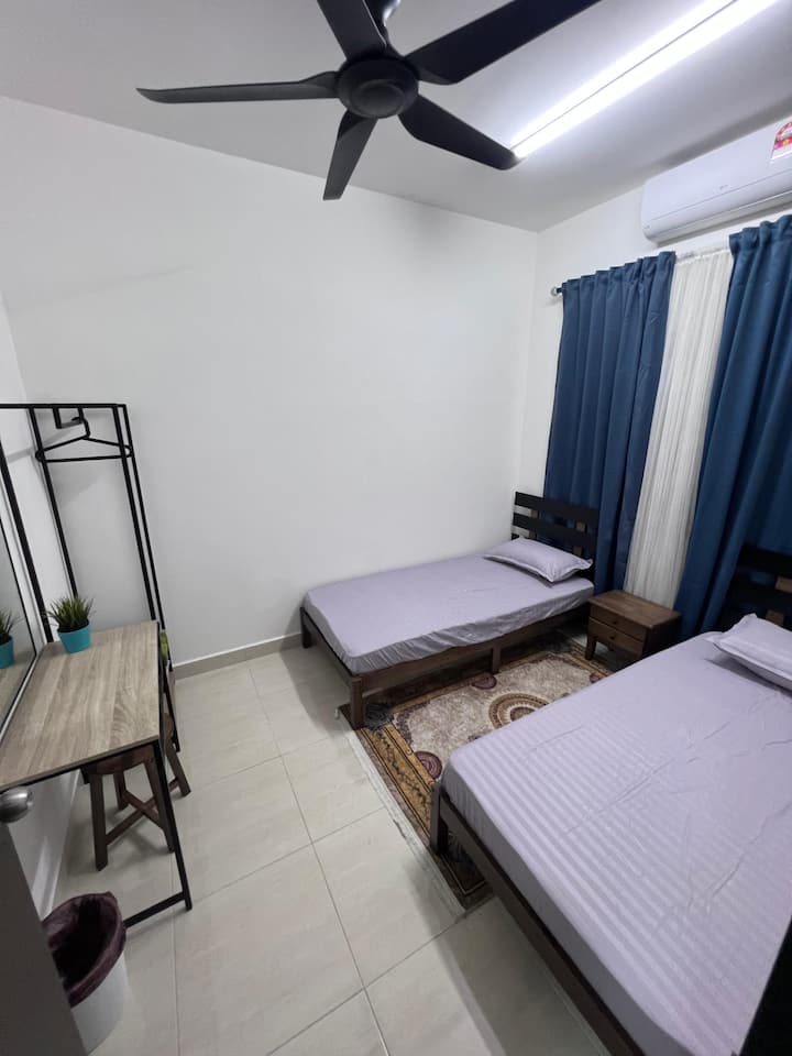 La chambre comprend 2 lits simples avec table de chevet, une coiffeuse avec un miroir et une armoire ouverte avec une tringle et un porte-vêtements