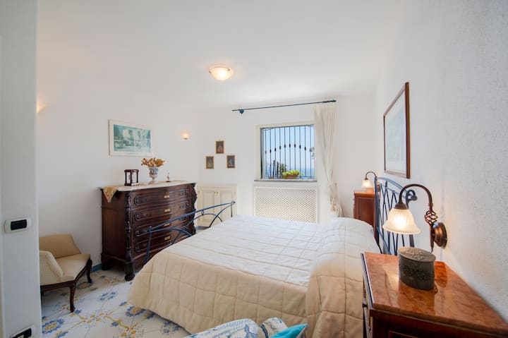 Rafinovaná a svetlá dvojlôžková izba, zariadená starožitným nábytkom, posteľou z tepaného železa a keramickou podlahou Vietri. Prostredie vyžaruje teplo a pokoj, z okna je výhľad na zeleň a záblesky mora.
