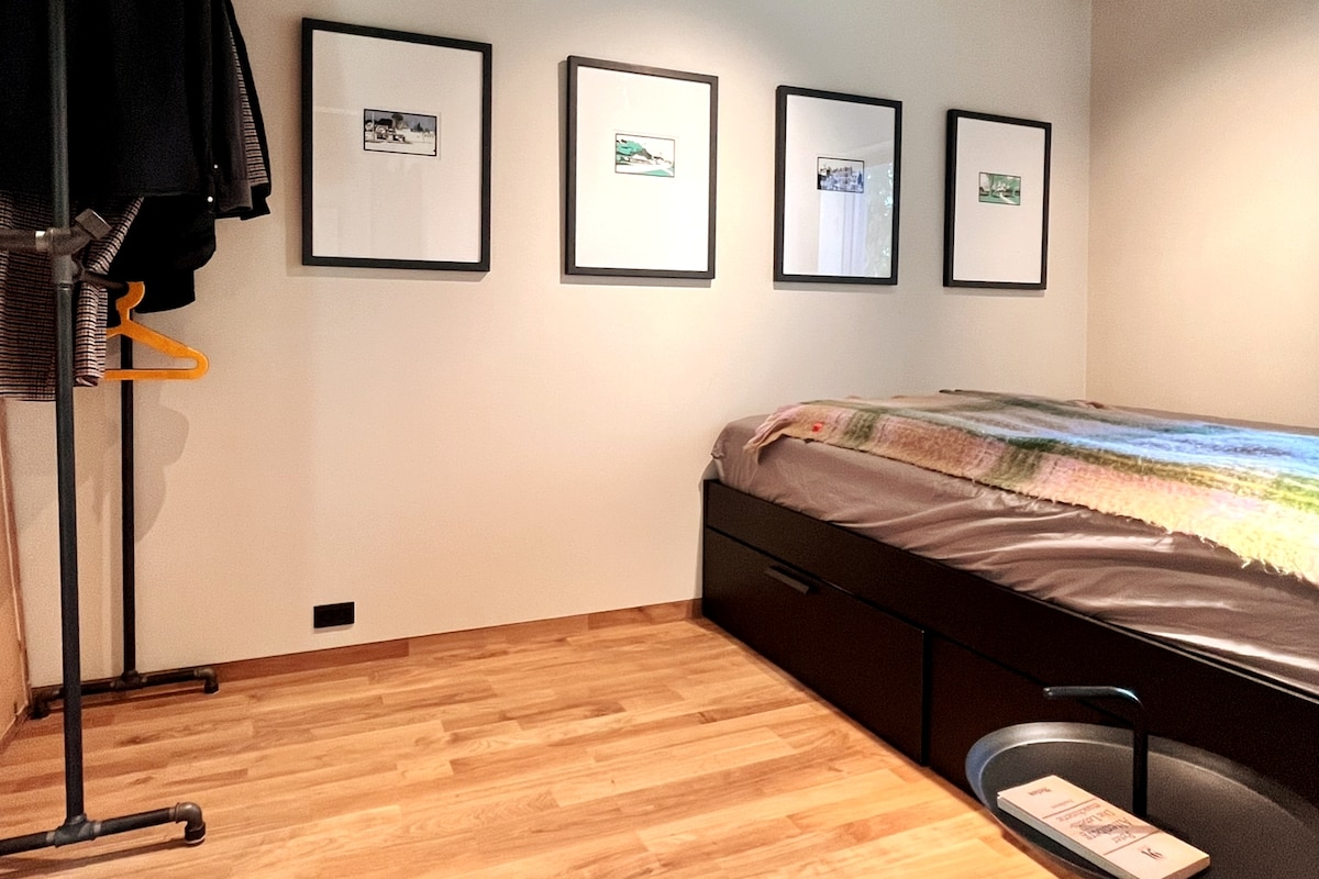 חדר שינה עם מתלה בגדים וקולבי בגדים. 