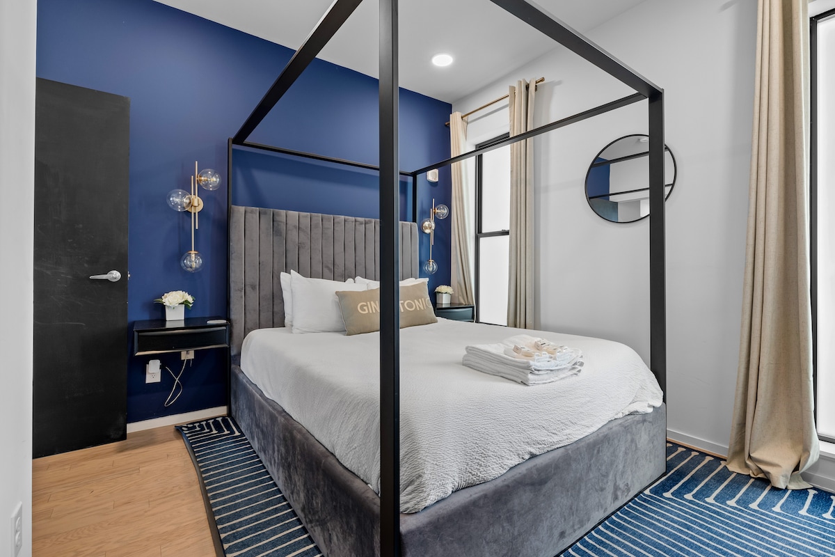 Comfort meets style in the second bedroom, featuring a queen-sized bed, smart TV, and large windows that flood the room with natural light and offer captivating views