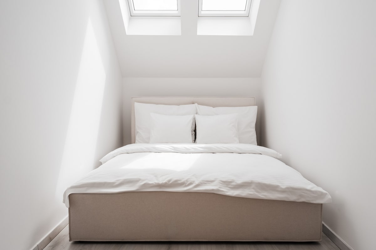 Licht slaapgedeelte met dubbele dakramen en een rustige sfeer.