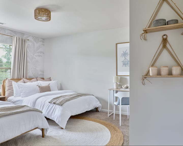 The Oasis Room includes two queen beds and a dedicated workspace, combining comfort and practicality in a calm, spacious setting.