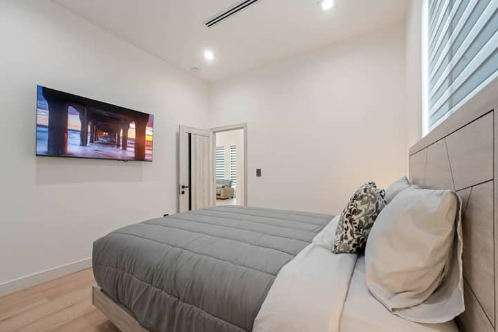 Prostrana spavaća soba s nježnim osvjetljenjem i mirnom, ugodnom atmosferom.