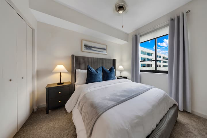 Dormitorio moderno y luminoso

- Un dormitorio acogedor con una cama lujosa, sábanas cómodas y una iluminación suave. La gran ventana aporta luz natural y vistas a la ciudad, creando un espacio tranquilo para relajarse y descansar.