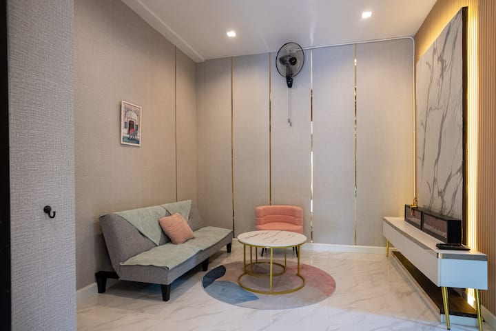 Уютен кът за сядане с пастелни щрихи – тихо кътче за почивка или четене в спокойна обстановка.