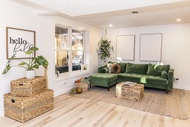 The living room is located on the walkout basement level of the cabin. It features a cozy couch, big screen tv and walks right out to one of the covered deck areas, fire pit and hot tub areas.