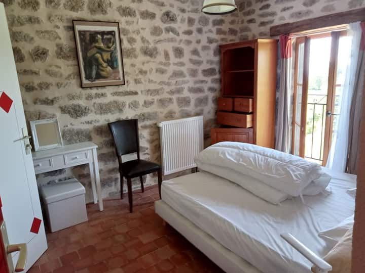 Bedroom with double bed, garden view and private bathroom with toilet.