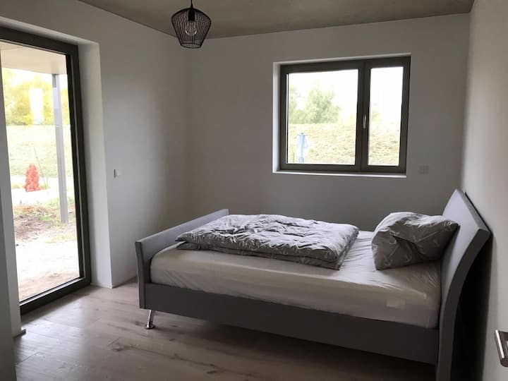 Amplio y muy luminoso dormitorio con cama de muelles de alta calidad de 1,60 m de ancho y mucha luz. Acceso directo a la terraza en el campo. 