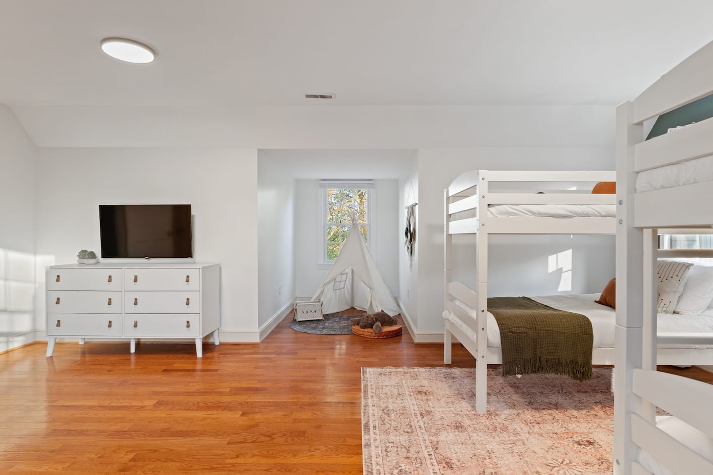 Bunk room with dresser and wood floors