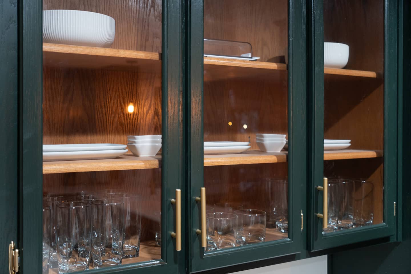 Glass-front cabinet with dishware and glassware