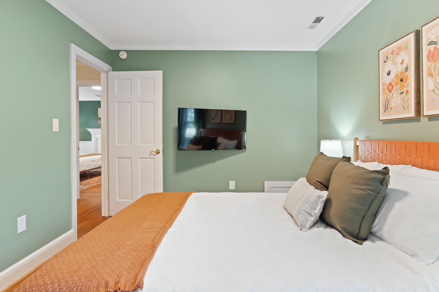 Bedroom with green walls and orange bedding