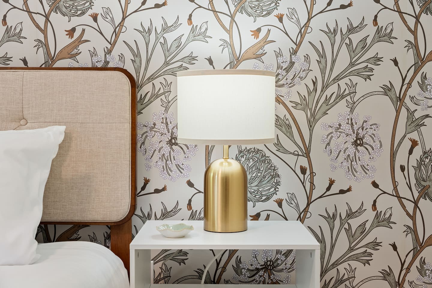 Bedroom nightstand with lamp and wallpaper detail