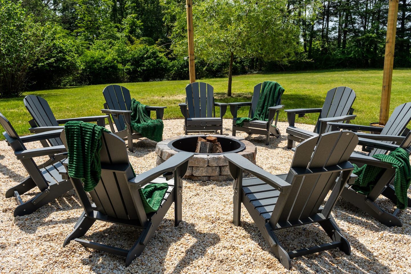 Fire pit ringed by Adirondack chairs