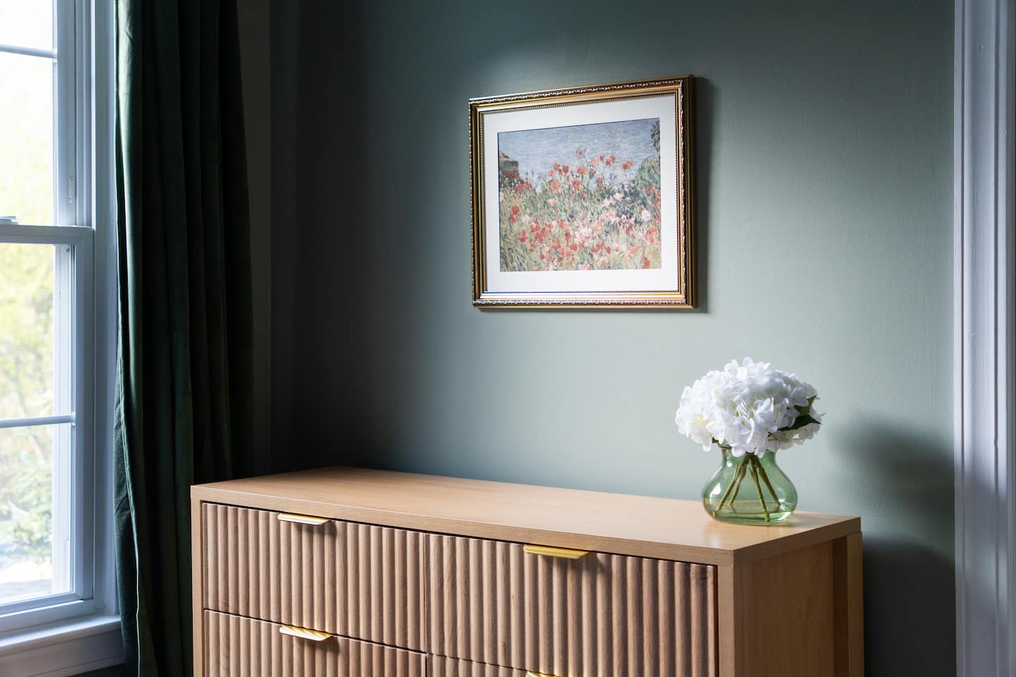 Bedroom dresser with framed art