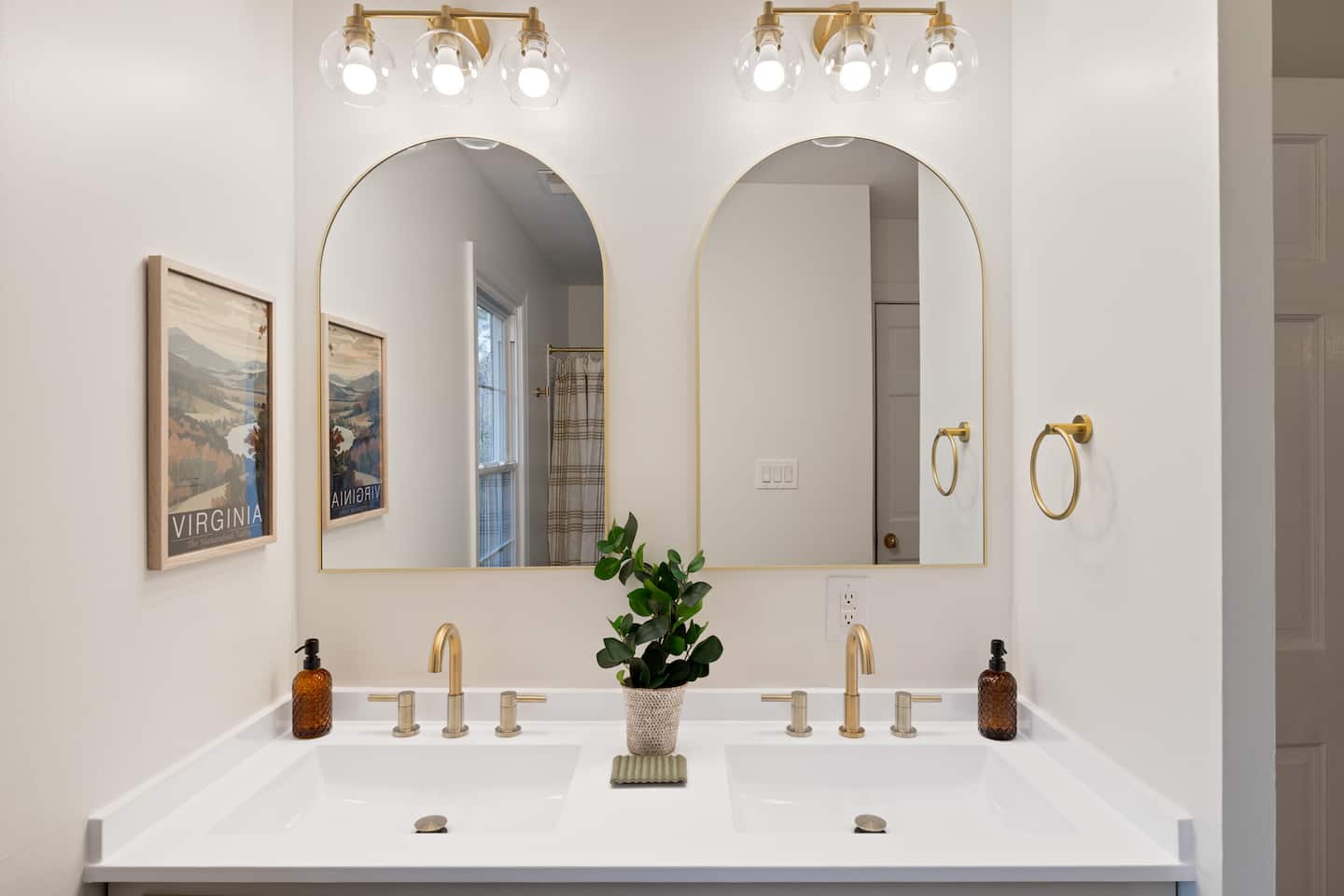 Bathroom with dual vanities and arched mirrors