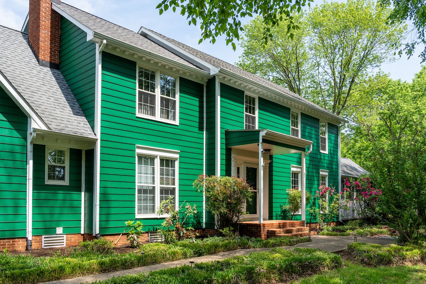 Photo 8 — Emerald Retreat's green exterior among the trees
