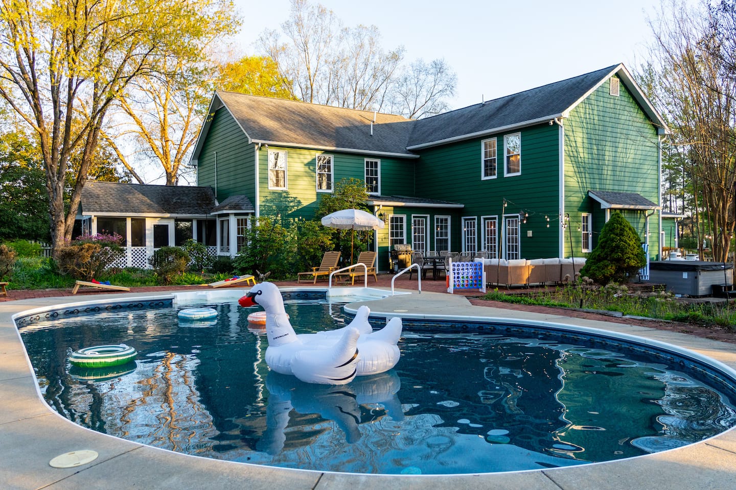 Pool with swan floats, house in the background