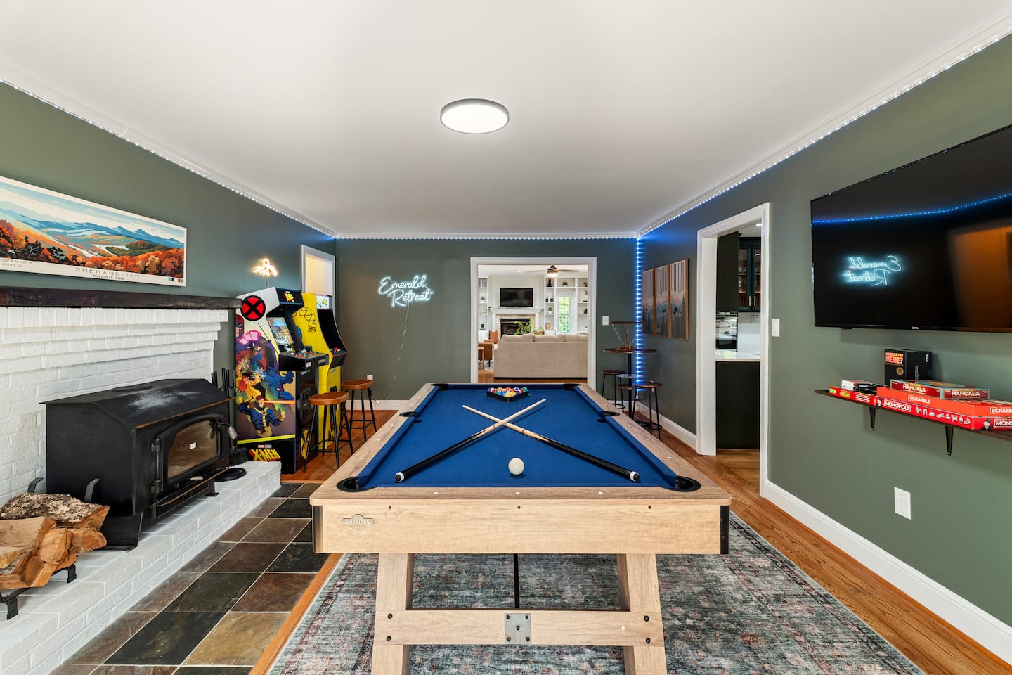 Photo 3 — Game room with pool table, arcade games, and TV
