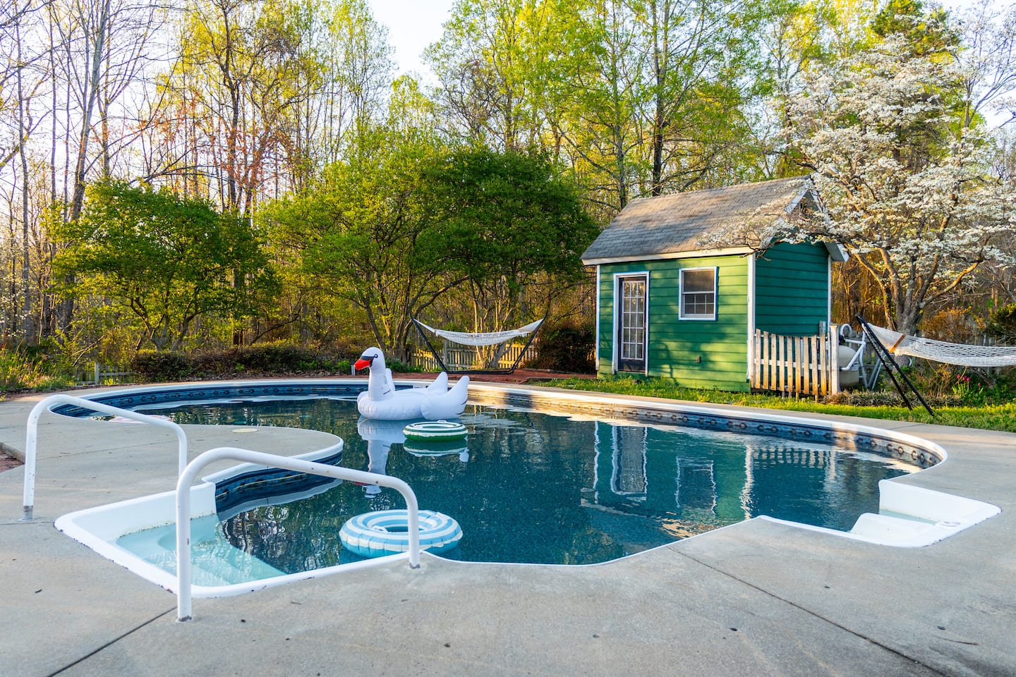 Pool with swan float, poolhouse in background