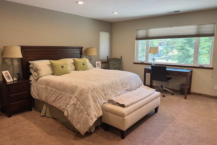 ห้องนอนใหญ่ขนาดใหญ่มีเตียงคิงไซส์ โต๊ะทำงานและที่นั่ง  