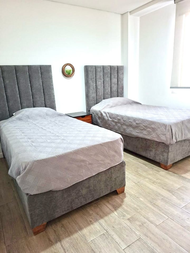 Segunda recámara con 2 camas individuales y cortinas blackout
