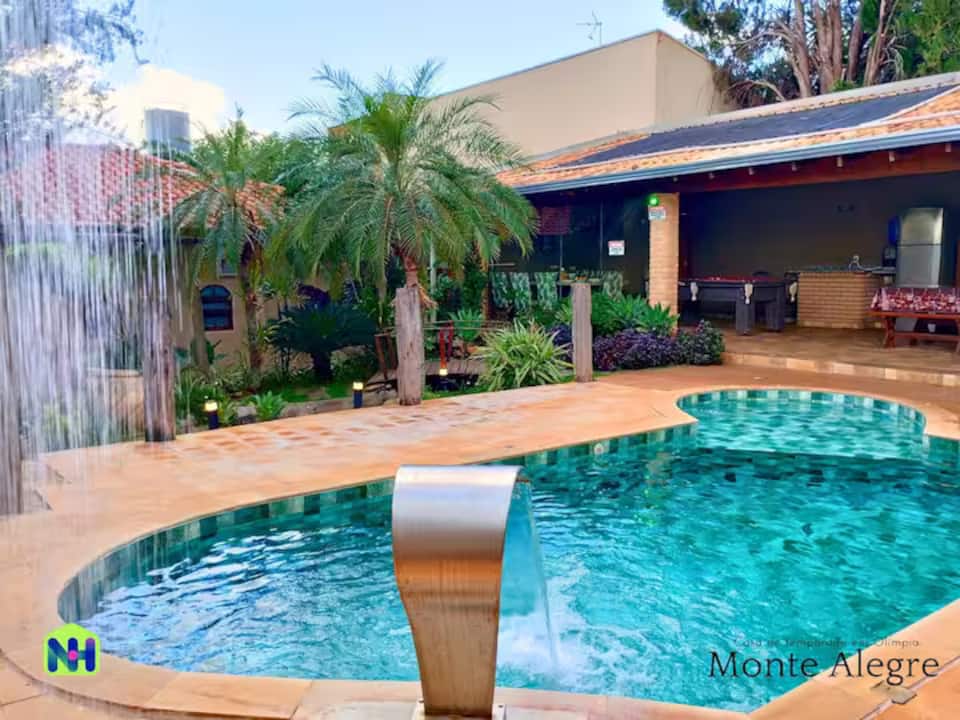 A piscina com cascata e os coqueiros