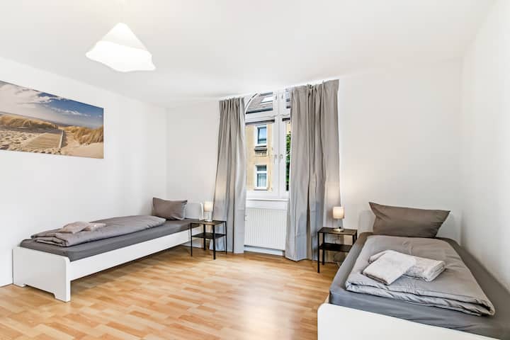 1号卧室配有两张单人床、起居区、智能电视  