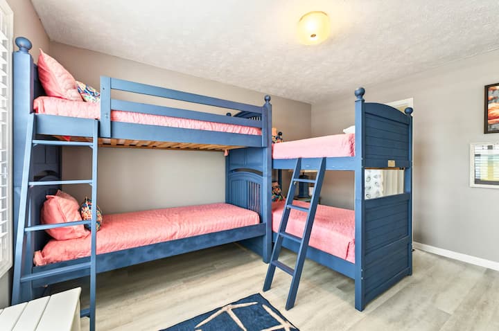 With four twin bunks and bold beachy colors, this fun-filled room is made for giggles and good sleep. It shares a Jack-and-Jill bath with the downstairs queen—ideal for kids or kids-at-heart.