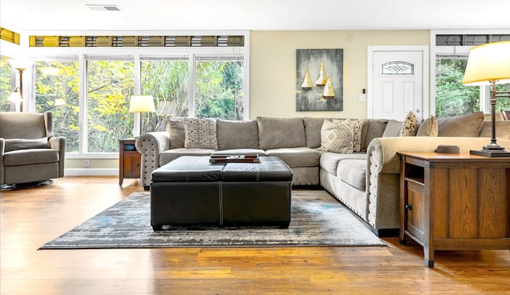 The living room has a wall of windows that look our to the backyard and River!