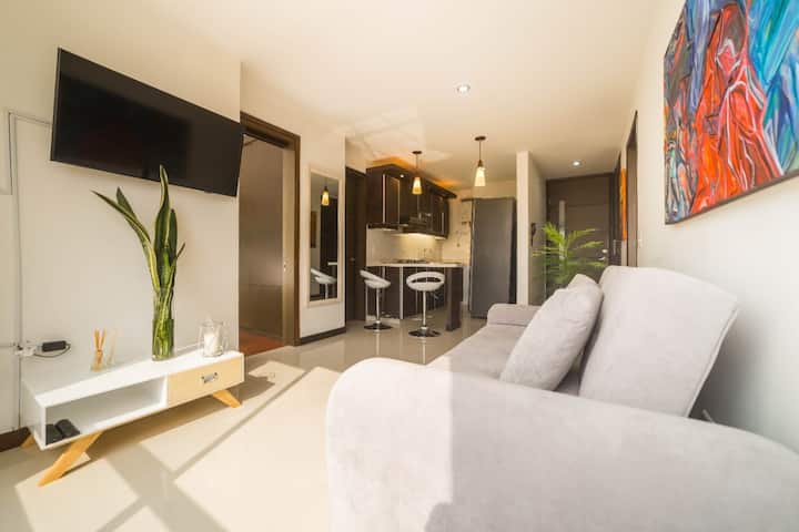 Светла дневна соба со удобни каучи и модерна декорација. Релаксирачката атмосфера е совршена за опуштање или уживање во филм. Со големи прозорци кои овозможуваат да влезе природна светлина, создавајќи удобен и топол простор