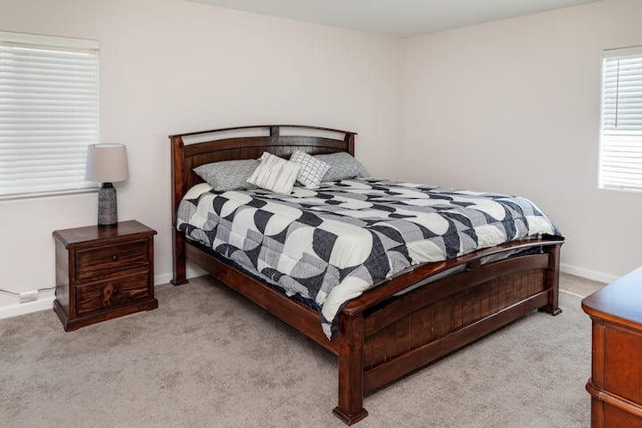  การพักผ่อนที่เงียบสงบของคุณ — ห้องนอนใหญ่กว้างขวางมีหน้าต่างบานใหญ่ เฟอร์นิเจอร์ไม้ที่มีสไตล์ และเตียงขนาดคิงไซส์
