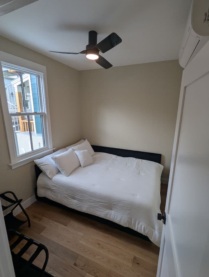 מיטת קווין סייז עם מזרן יוקרה ושני מגירות מתחתיה לאחסון בגדים.