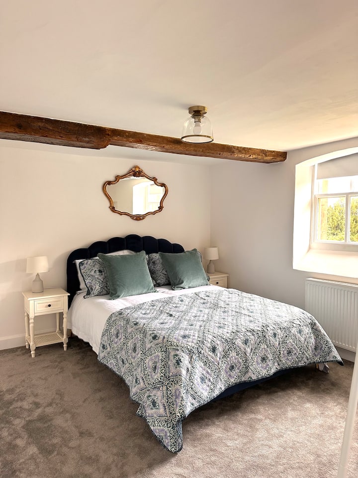 ห้องนอนขนาดคิงไซส์พร้อมห้องน้ำในตัวและวิวข้ามสี่เหลี่ยมด้านหน้าของอาคารหลัก