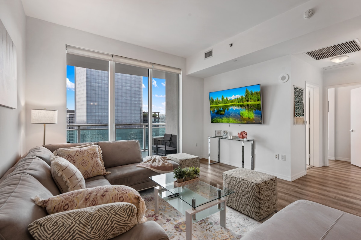 Всекидневна с уютни места за сядане и смарт телевизор, идеална за отдих или работа от разстояние.