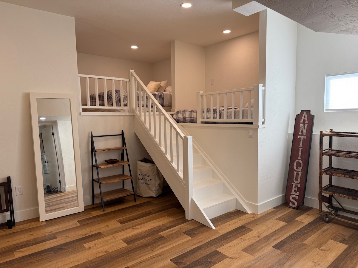 Velika treća spavaća soba na nižoj razini s povišenim bračnim krevetom i dvostrukim krevetima. 