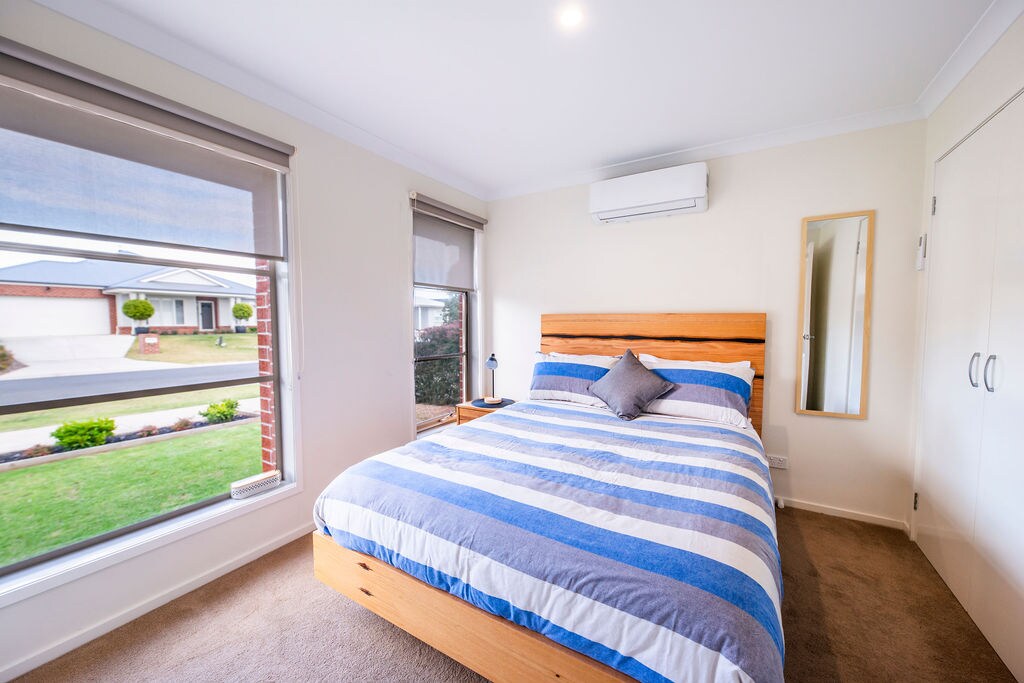 Klimatizovaná spálňa s veľkým skleneným oknom a zatemňovacou clonou pre pokojný spánok.