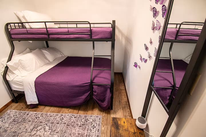 חדר שינה 4: החדר הסגול
חדר שינה מקסים בקומה הראשית עם מיטת קומותיים זוגית, מושלם לילדים או לצרכי שינה גמישים. מצעים נקיים ואווירה נעימה כלולים.
