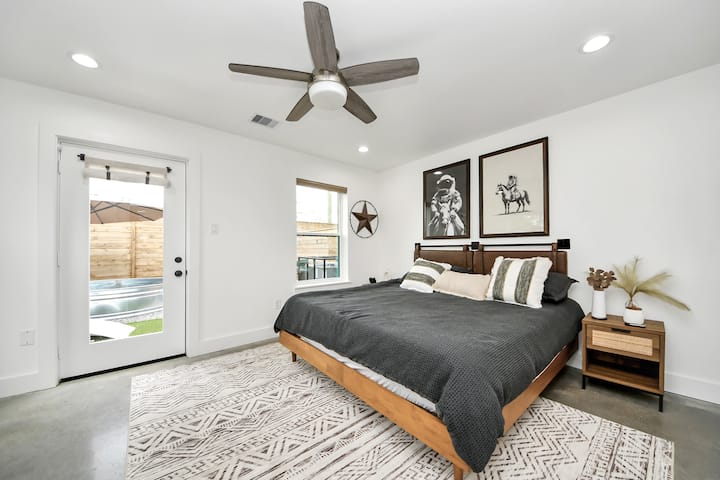 Chumba chenye mandhari ya anga ya chini kilicho na kitanda cha kifalme na ufikiaji wa moja kwa moja wa ua wa nyuma. Ubunifu wa futuristic na maelezo ya ulimwengu huleta mtikisiko wa kweli wa anga kwenye ukaaji wako.